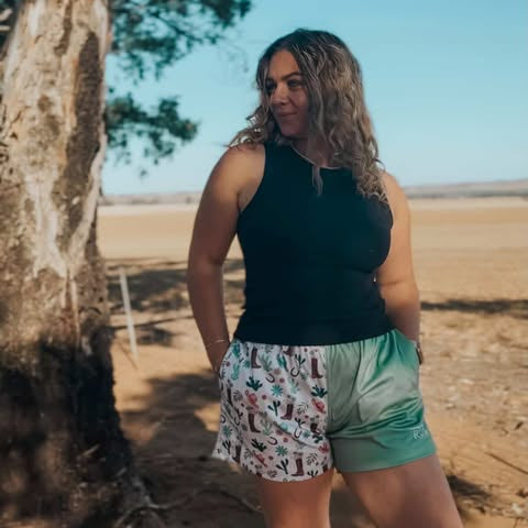 Person standing under a tree in a desert-like setting