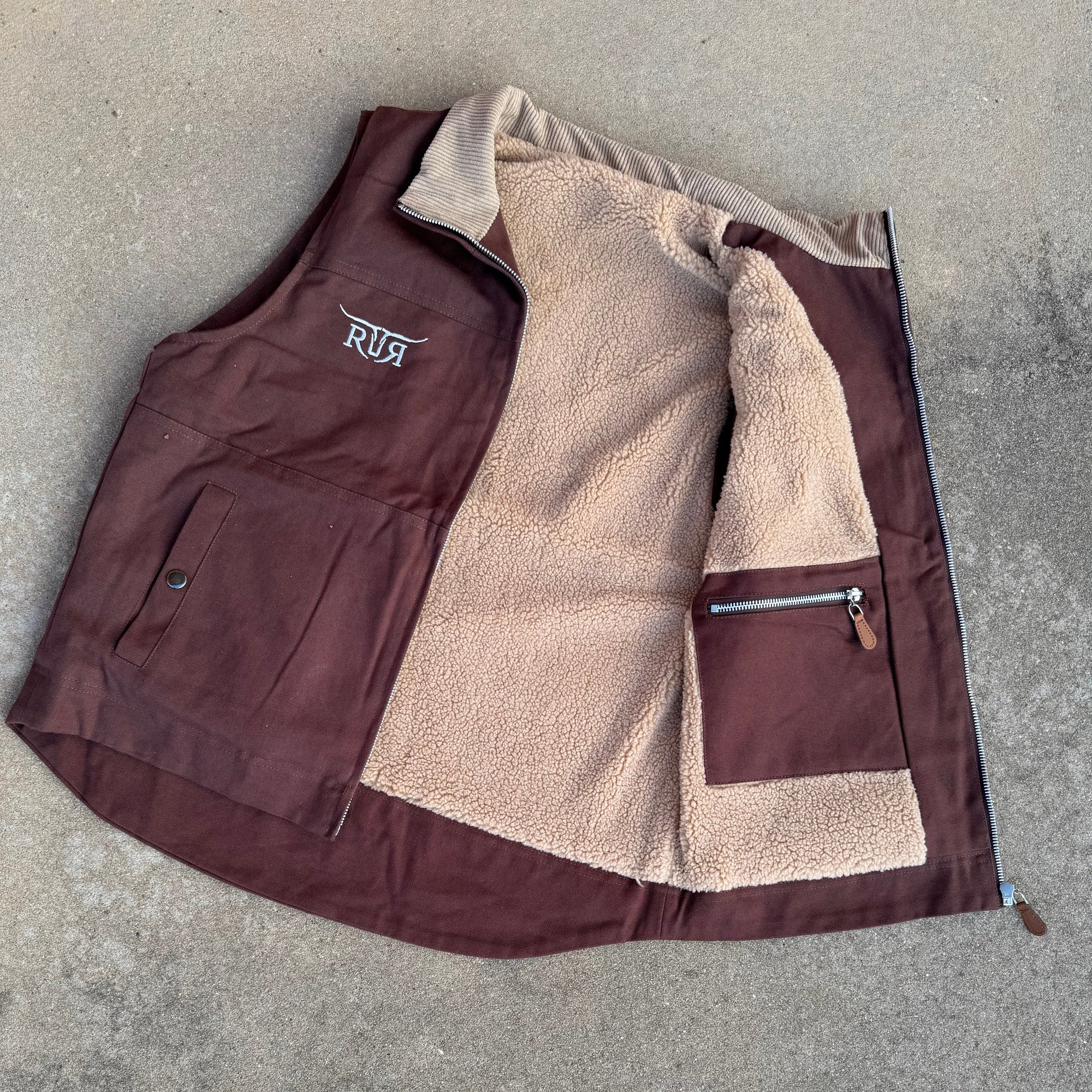 Folded brown and beige jacket on a concrete surface