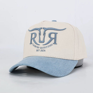 A baseball cap with an off-white crown and a light blue denim-look brim, featuring a blue embroidered logo on the front that reads 'RR COUNTRY OUTFITTERS EST 2024'.