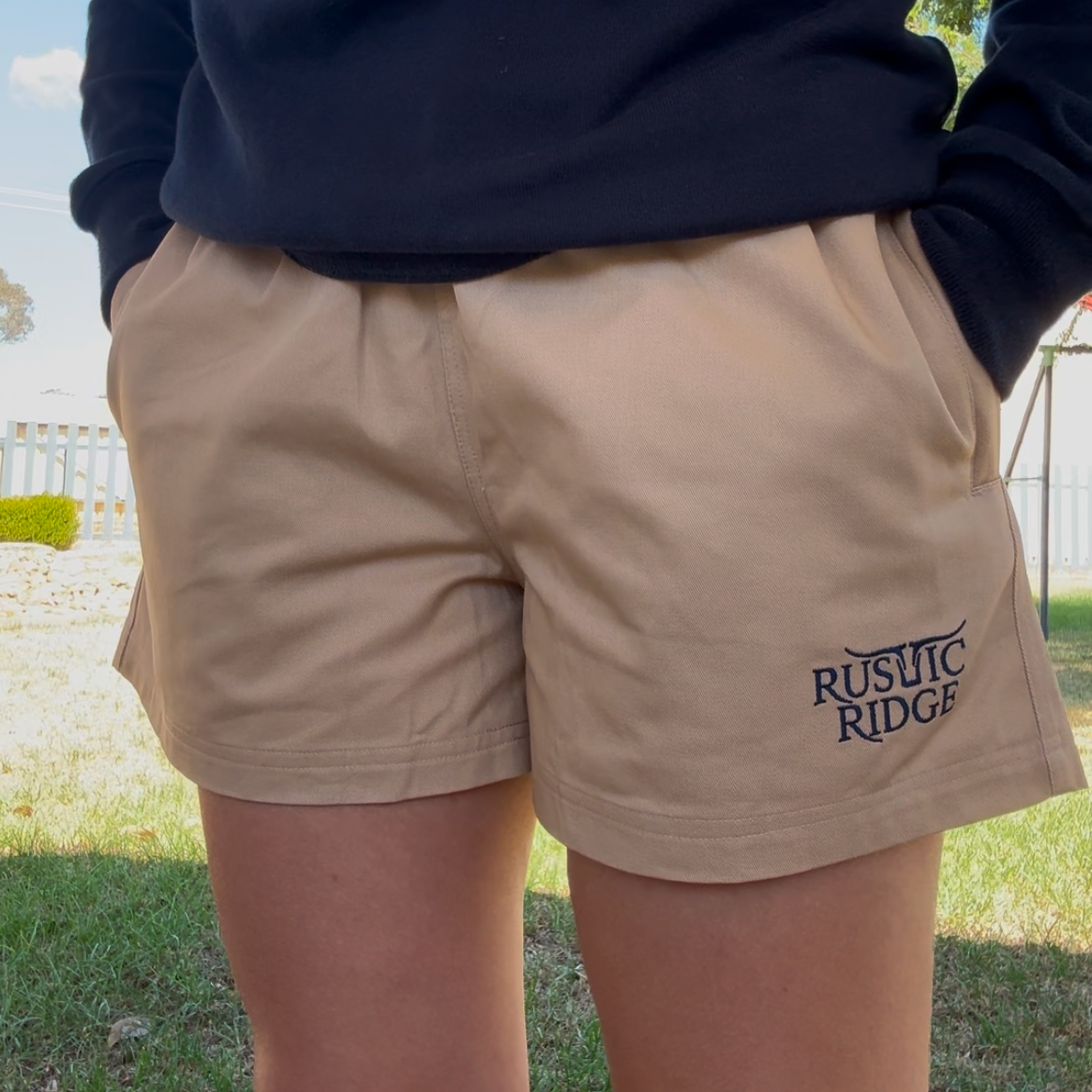 Person wearing a sports sweater and shorts with 'RUSTIC RIDGE' branding outdoors.