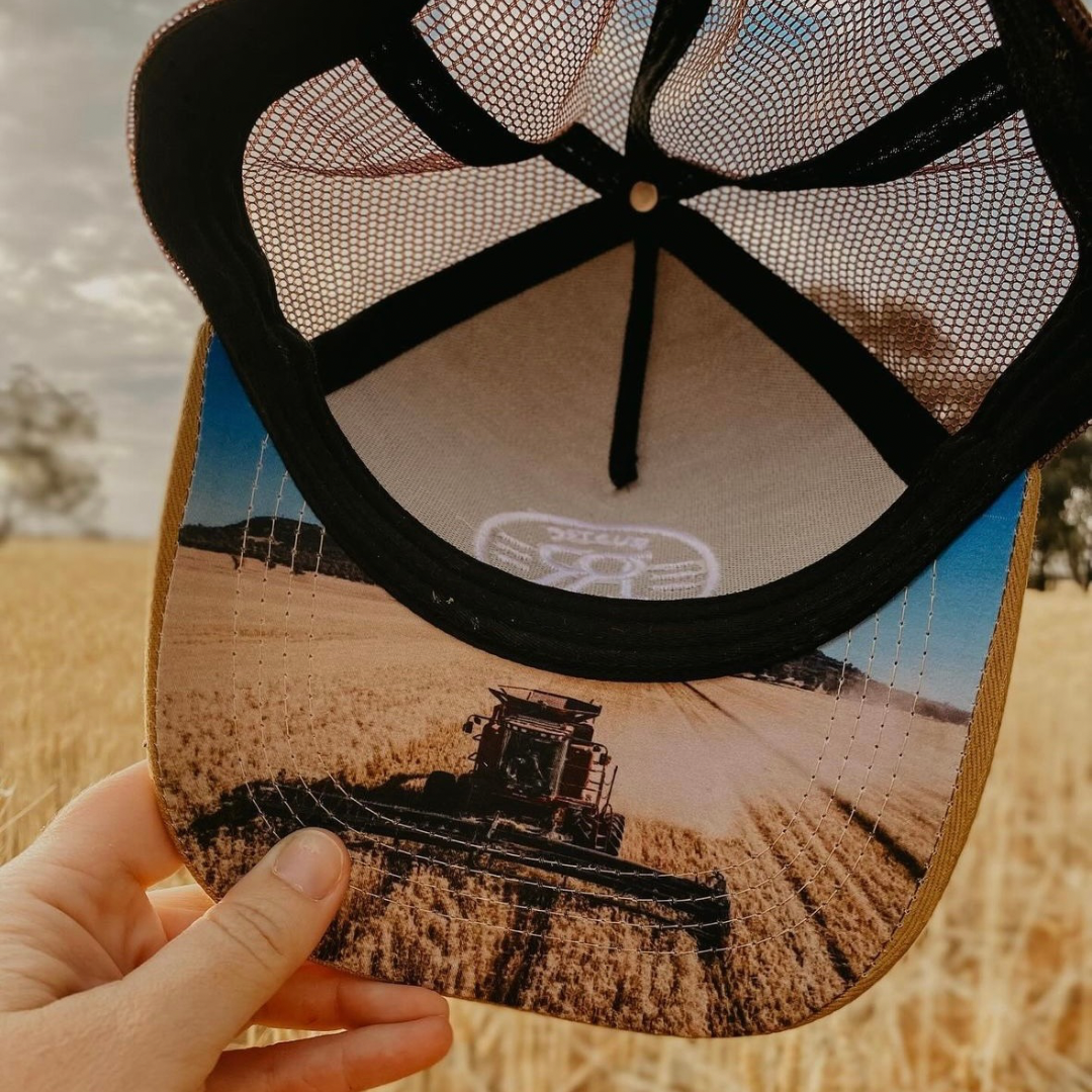 Trucker cap with a photo of a header under the brim. 
