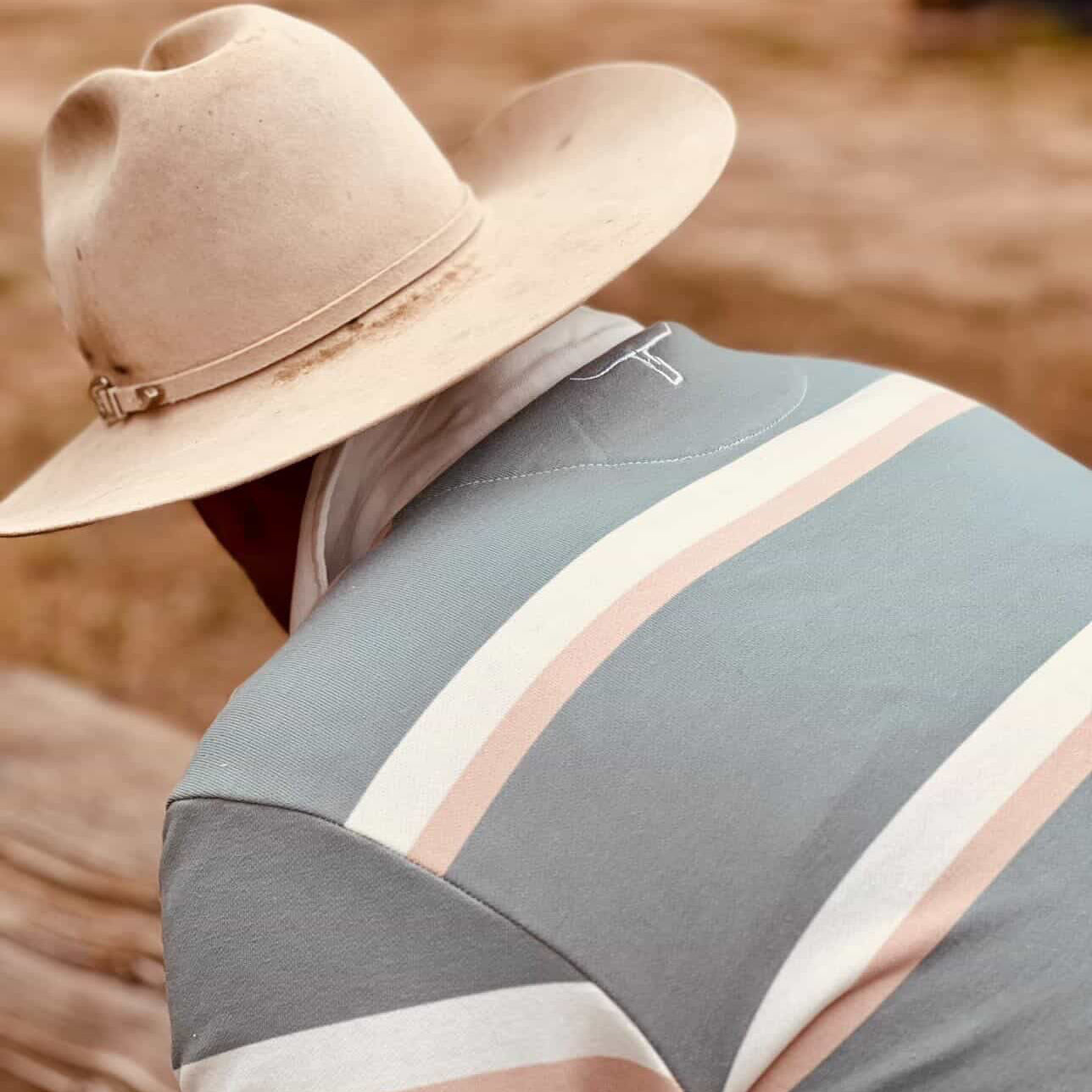 Person wearing a wide-brimmed hat and a striped shirt in an outdoor setting