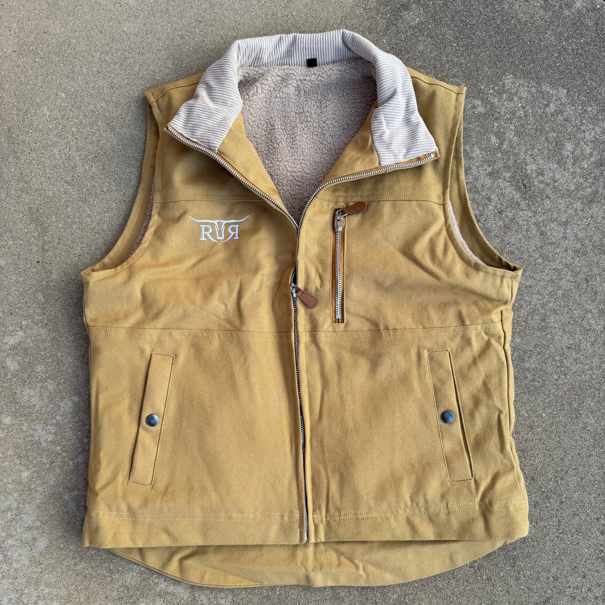 Beige jacket with visible branding on a gray surface