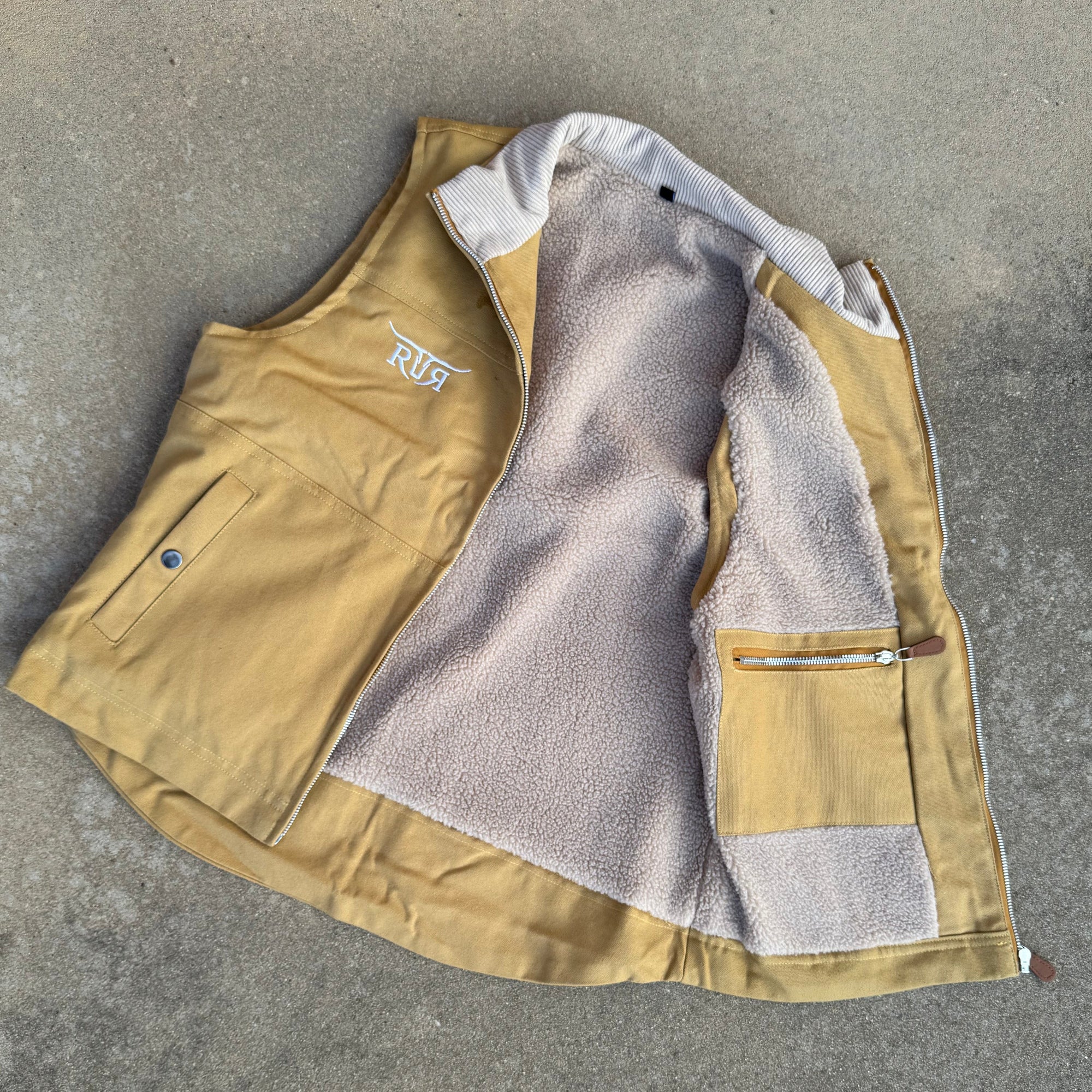 Beige jacket with gray lining on a concrete surface