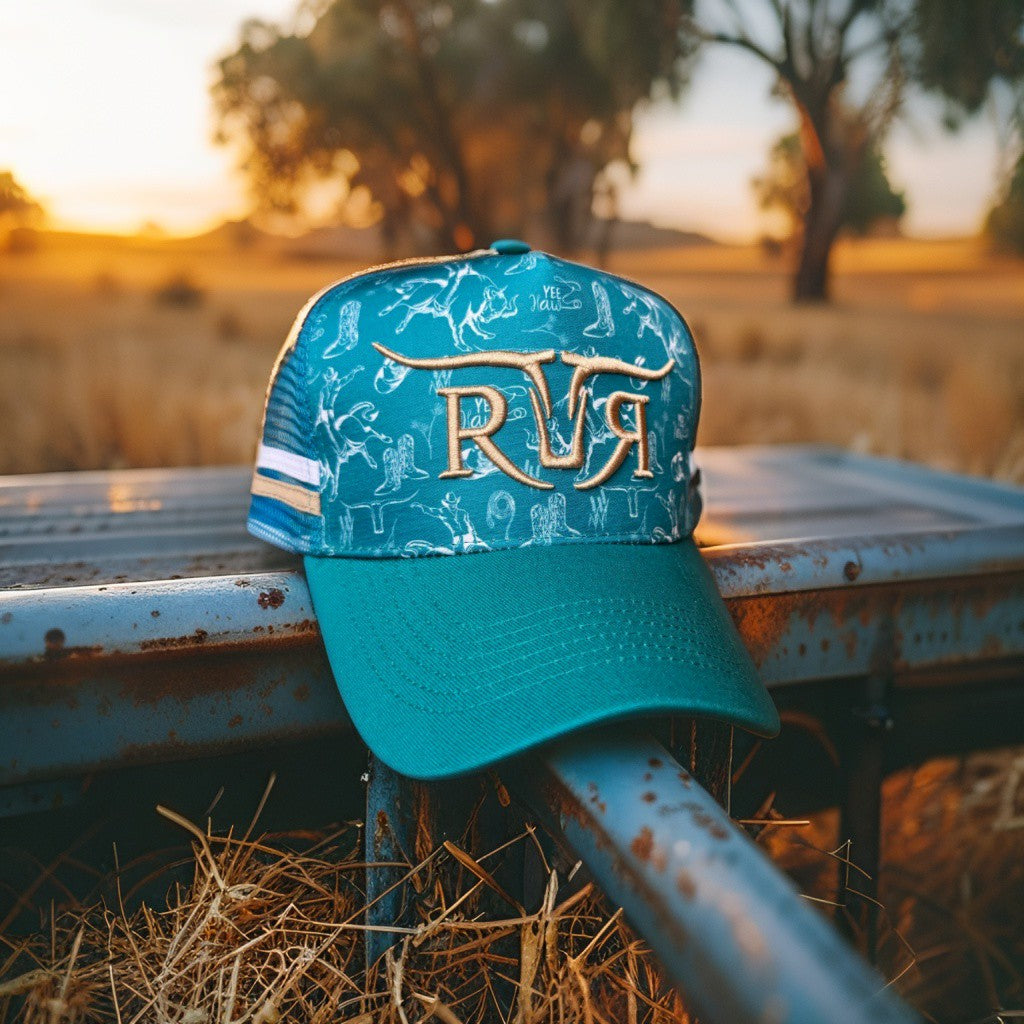 Teal cap with 'RR' logo on a metal surface with a sunset background