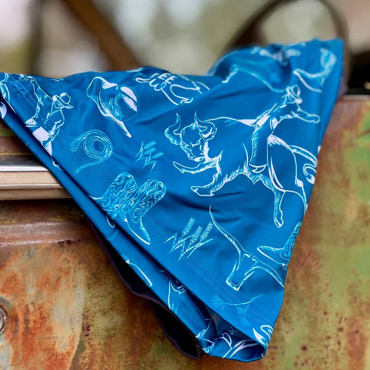 Blue shorts with white animal illustrations on a wooden surface