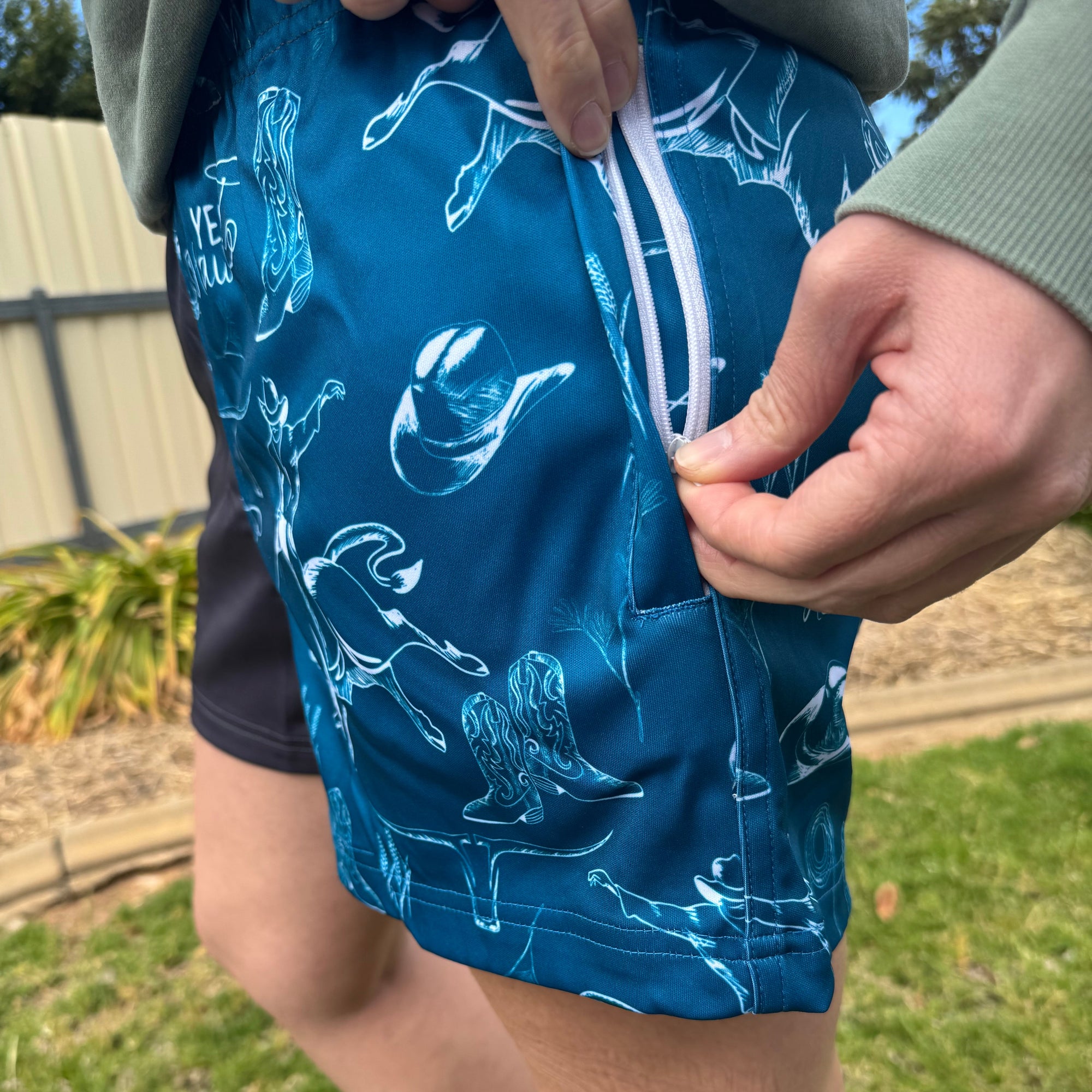 Person holding a blue bag with white patterns on a grassy background